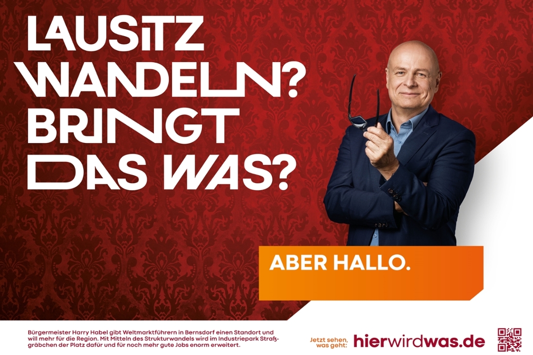 #hierwirdwas Plakat. Der Bürgermeister von der Stadt Bernsdorf, Harry Habel lächelt in die Kamera. Auf dem Plakat steht Lausitz wandeln? Bringt das was?. Unter Harry Habel steht Aber Hallo.